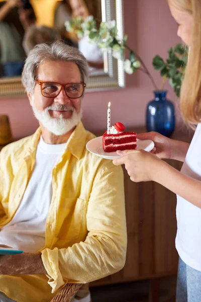 Adorável menina trata avô com bolo de aniversário — Fotografia de Stock