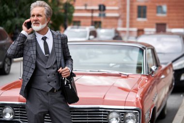 Zengin otomobilinin yanındaki Kafkas girişimcisi.