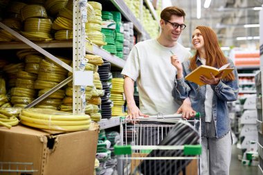 Kafkasyalı çift birlikte alışveriş yapıyor. Bilgi defterini kullanın.