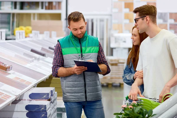 Trabalhador armazém responsivo consultar clientes no mercado — Fotografia de Stock