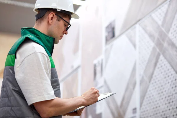 Geconcentreerde jonge magazijnmedewerker in de productieafdeling van de moderne winkel — Stockfoto