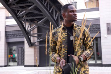 Kendine güvenen, şık giyinmiş, ciddi bir Afrikalı adamın portresi.