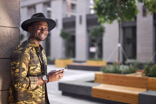 Bien parecido negro macho uso de teléfono inteligente mientras él está caminando —  Fotos de Stock