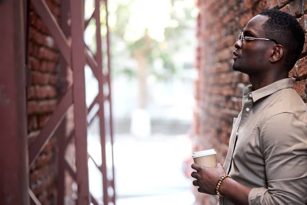 Vista lateral sobre o homem africano sério com xícara de café — Fotografia de Stock