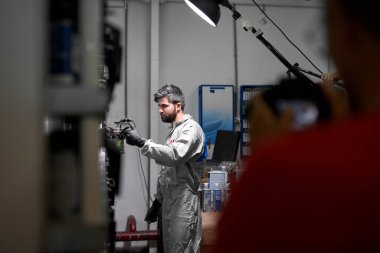 Üniformalı yakışıklı beyaz adam araba boyamak için uygun rengi seçiyor.