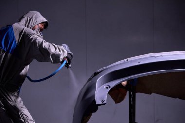 Otomobil tamircisi otomotiv imalat endüstrisinde araba boyama detaylarıyla ilgileniyor.