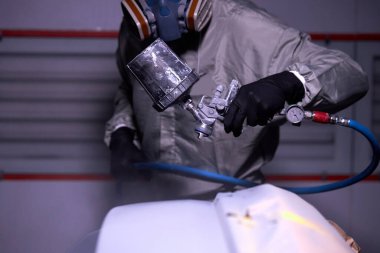 Otomobil tamircisi otomotiv imalat endüstrisinde araba boyama detaylarıyla ilgileniyor.