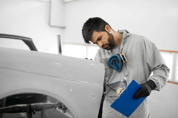 Jong auto monteur man voert diagnostiek van de auto lichaam voordat de renovatie — Stockfoto