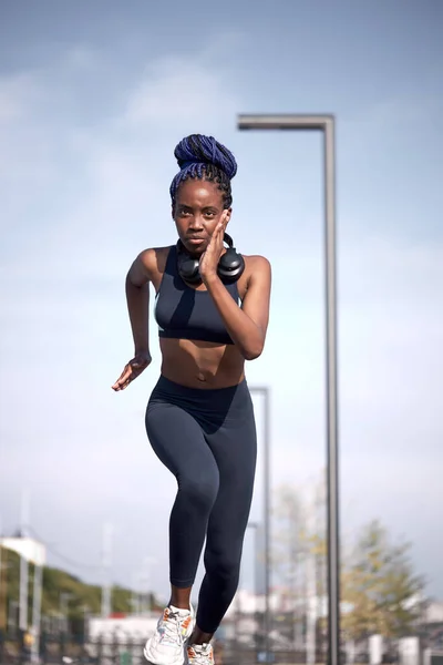 young black fitness woman running in stadium