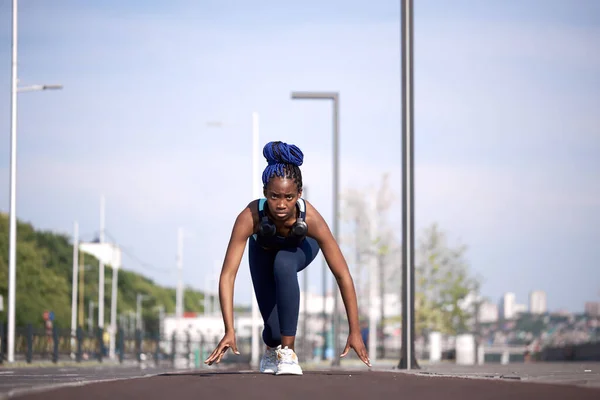 Αθλητική Αφροαμερικανή στέκεται στην αρχή, έτοιμη να τρέξει. — Φωτογραφία Αρχείου