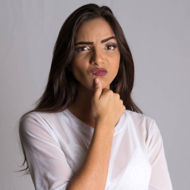 Uzun saçlı, suratını buruşturan ve ciddi bir ifadeyle kameraya bakan Brezilyalı genç bir kadının portresi..