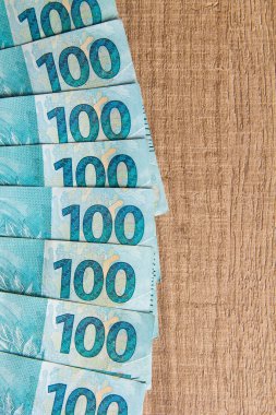 Brezilya 'dan gelen para. Gerçek, Brezilya para biriminin notları. Tasarruf, maaş, ödeme ve fon kavramı. Tahta masada bir grup fatura.