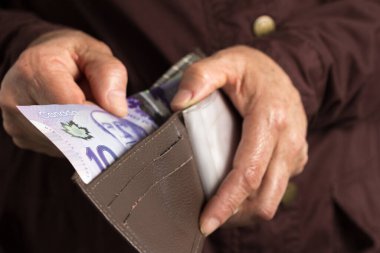 Kanada parası. Dolar. Kanada 'dan gelen para. Nakit ödeyen yaşlı bir adam..
