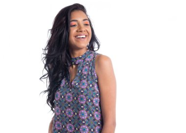 Genç siyah kızın güzel gülümsemesi. Yana bakıyor. Melez ırktan Brezilyalı bir kadın çiçek desenli renkli mor bir elbise giyiyor. Yaz. Tropik makyaj..