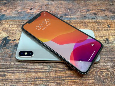 BALI, INDONESIA JUNE 29 Haziran 2020: Iphone X ahşap desenli, üst görüşlü bir masada kullanılmıştır. en son iPhone ürünleri.