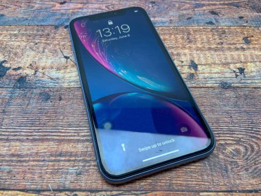 BALI, INDONESIA JUNE 29 Haziran 2020: Iphone XR Blue Ahşap desenli, üst görüşlü bir masada kullanılmıştır. en son iPhone ürünleri.