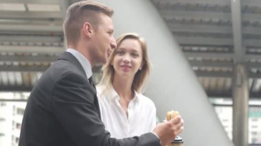 İş adamı ve iş kadınları bir kahve fincanı ve hamburger üzerinde sky ile iş kavramı sabah yürüyüşe.