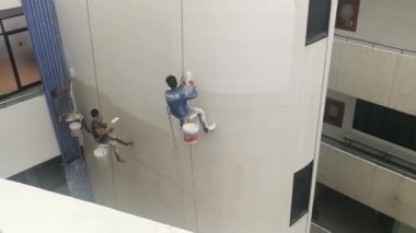 Bangkok, Tayland - Aralık, 3 2018: Ressamlar büyük ip ile yüksek binalar üzerinde boya vardır.