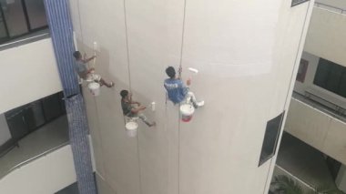 Bangkok, Tayland - Aralık, 3 2018: Ressamlar büyük ip ile yüksek binalar üzerinde boya vardır.