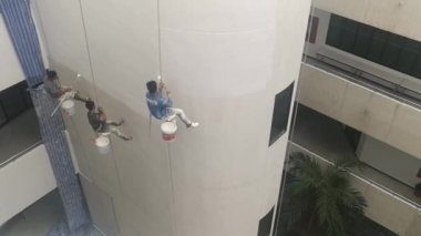 Bangkok, Tayland - Aralık, 3 2018: Ressamlar büyük ip ile yüksek binalar üzerinde boya vardır.