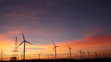  Rüzgar türbinleri ve gün batımına karşı güç hatları. Khao Kho District, Phetchabun Eyaleti, Tayland temiz enerji sistemi.