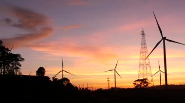  Rüzgar türbinleri ve gün batımına karşı güç hatları. Khao Kho District, Phetchabun Eyaleti, Tayland temiz enerji sistemi.
