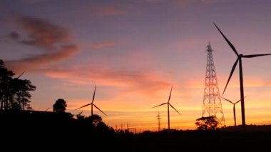  Rüzgar türbinleri ve gün batımına karşı güç hatları. Khao Kho District, Phetchabun Eyaleti, Tayland temiz enerji sistemi.