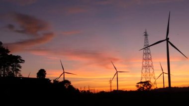  Rüzgar türbinleri ve gün batımına karşı güç hatları. Khao Kho District, Phetchabun Eyaleti, Tayland temiz enerji sistemi.