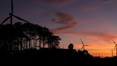  Rüzgar türbinleri ve gün batımına karşı güç hatları. Khao Kho District, Phetchabun Eyaleti, Tayland temiz enerji sistemi.