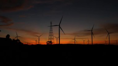  Rüzgar türbinleri ve gün batımına karşı güç hatları. Khao Kho District, Phetchabun Eyaleti, Tayland temiz enerji sistemi.