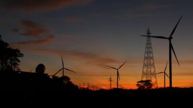  Rüzgar türbinleri ve gün batımına karşı güç hatları. Khao Kho District, Phetchabun Eyaleti, Tayland temiz enerji sistemi.