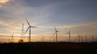  Rüzgar türbinleri ve gün batımına karşı güç hatları. Khao Kho District, Phetchabun Eyaleti, Tayland temiz enerji sistemi.