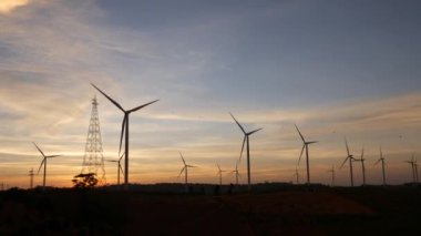  Rüzgar türbinleri ve gün batımına karşı güç hatları. Khao Kho District, Phetchabun Eyaleti, Tayland temiz enerji sistemi.