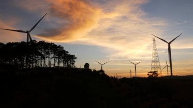  Rüzgar türbinleri ve gün batımına karşı güç hatları. Khao Kho District, Phetchabun Eyaleti, Tayland temiz enerji sistemi.