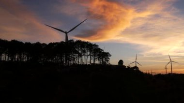  Rüzgar türbinleri ve gün batımına karşı güç hatları. Khao Kho District, Phetchabun Eyaleti, Tayland temiz enerji sistemi.