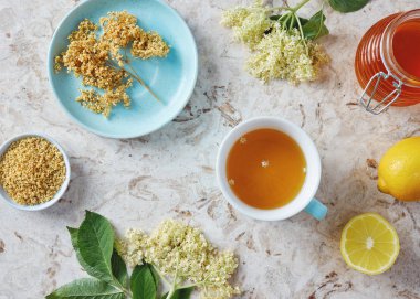 Fincan taze ve kurutulmuş çiçeklerle elderflower çay ve limon bal tablo ile 