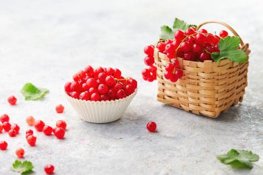 Redcurrants küçük hasır sepet ve beyaz arka plan üzerinde izole kase