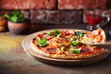 Fırından yeni çıkmış ince hamur pizza jambon ve peynir zeytin ahşap tablo