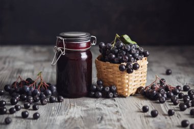 Aronia reçel yanında taze çilek. Ev yapımı aronia reçeli cam ahşap masa üzerinde taze aronia çilek ile.