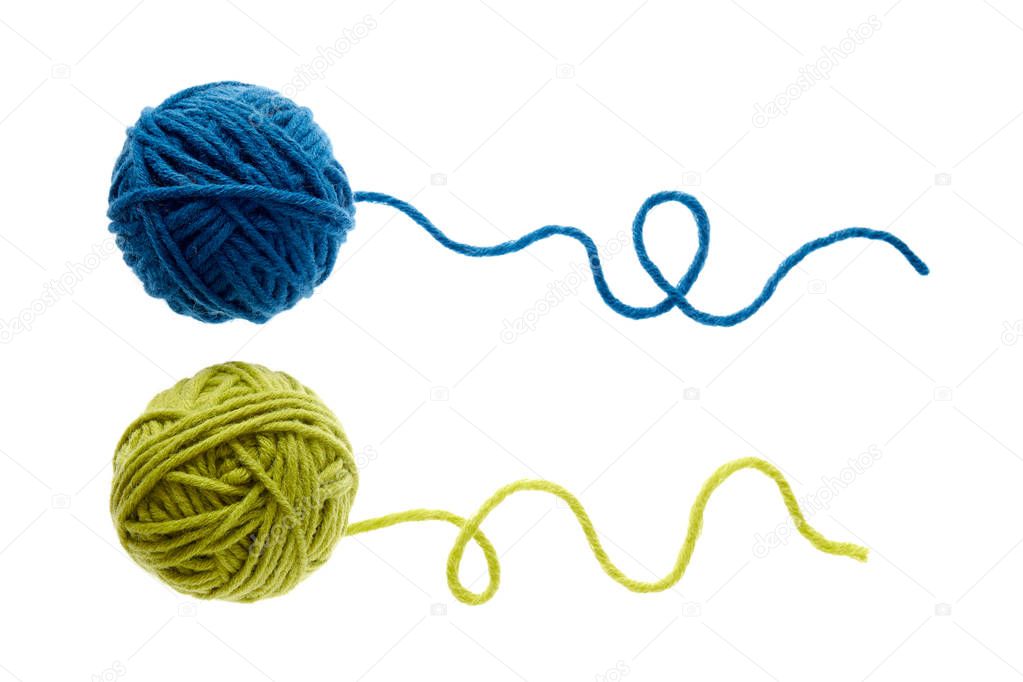 Blue and green woolen balls over white background