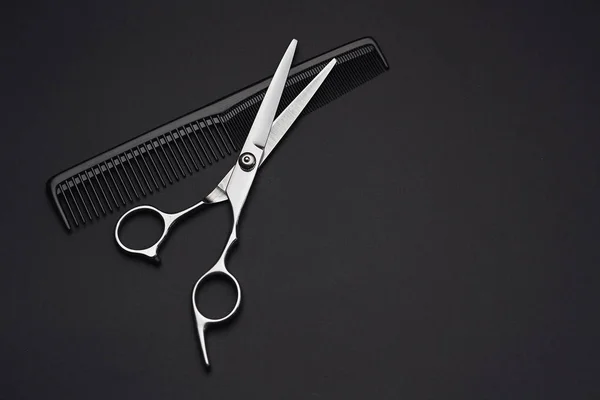 美发师剪刀与黑色背景梳子 — 图库照片