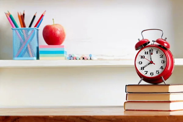 Reloj despertador encima de los libros en la mesa —  Fotos de Stock