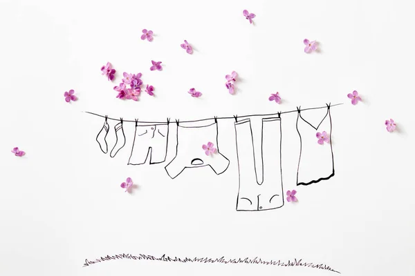 Fioletowe kwiaty bzu z rysunkiem linii ubrań z pralnią — Zdjęcie stockowe