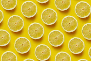Sarı arka planda taze dilimlenmiş limon.