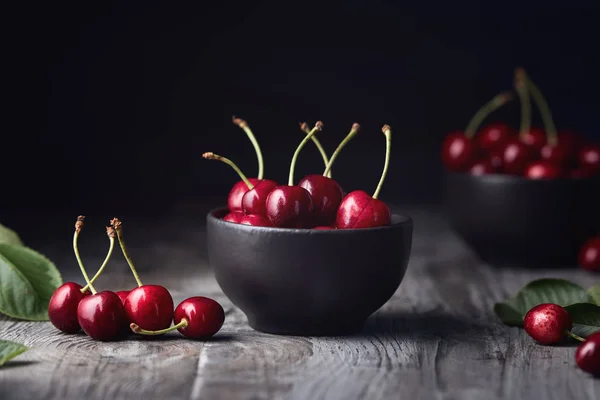 Ripe red cherries in a bowl and next to it — Stock Photo, Image