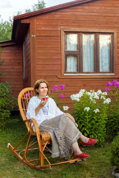 Usmívající Žena Odpočívá Proutěném Křesle Letní Chatě Večer — Stock fotografie