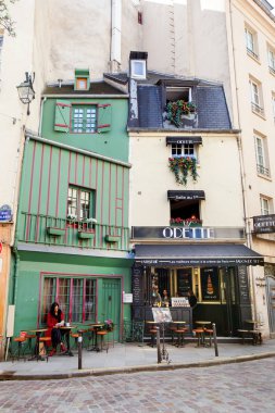 Paris, Fransa - 27 Mart 2019 Odette pastanesinde bir kadın oturuyor.