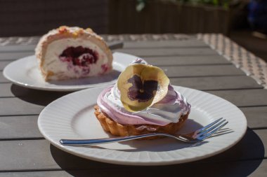 Bir sokak kafesinin masasında, muhallebi çocuğu pastalar.