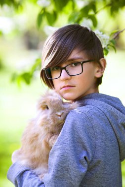 Parkta küçük bir tavşanı olan 11 yaşındaki çocuk.