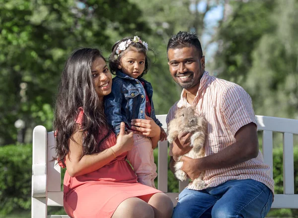 市内の公園でウサギと幸せな家族の父と母と小さな女の子 — ストック写真
